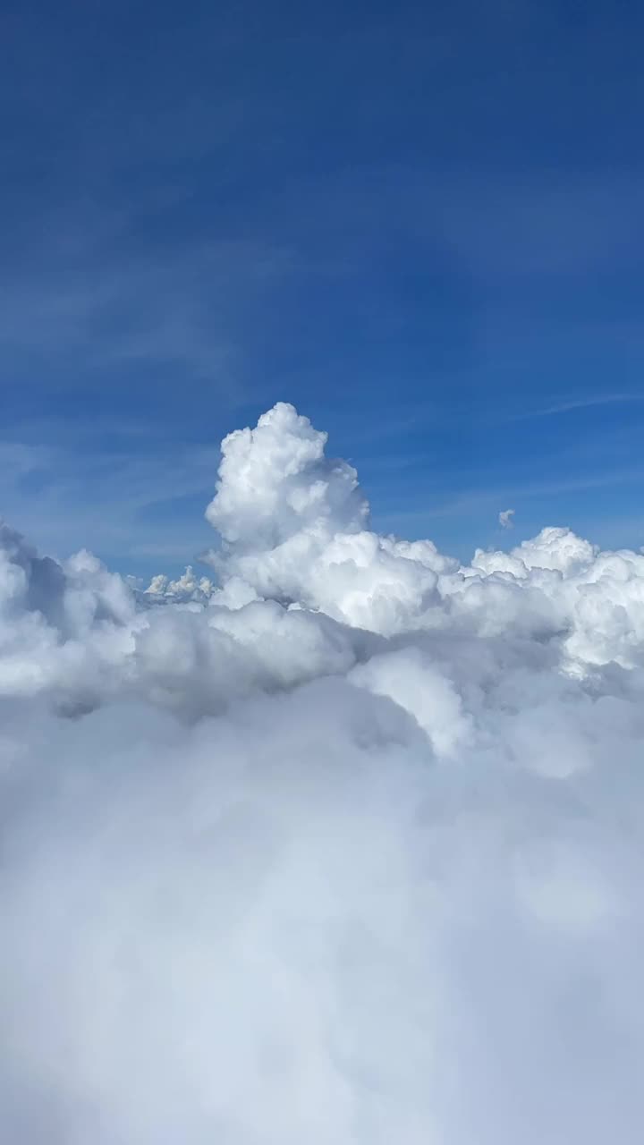 时间圈从飞机窗口的云和降落在一个绿色的景观。垂直拍摄。视频下载