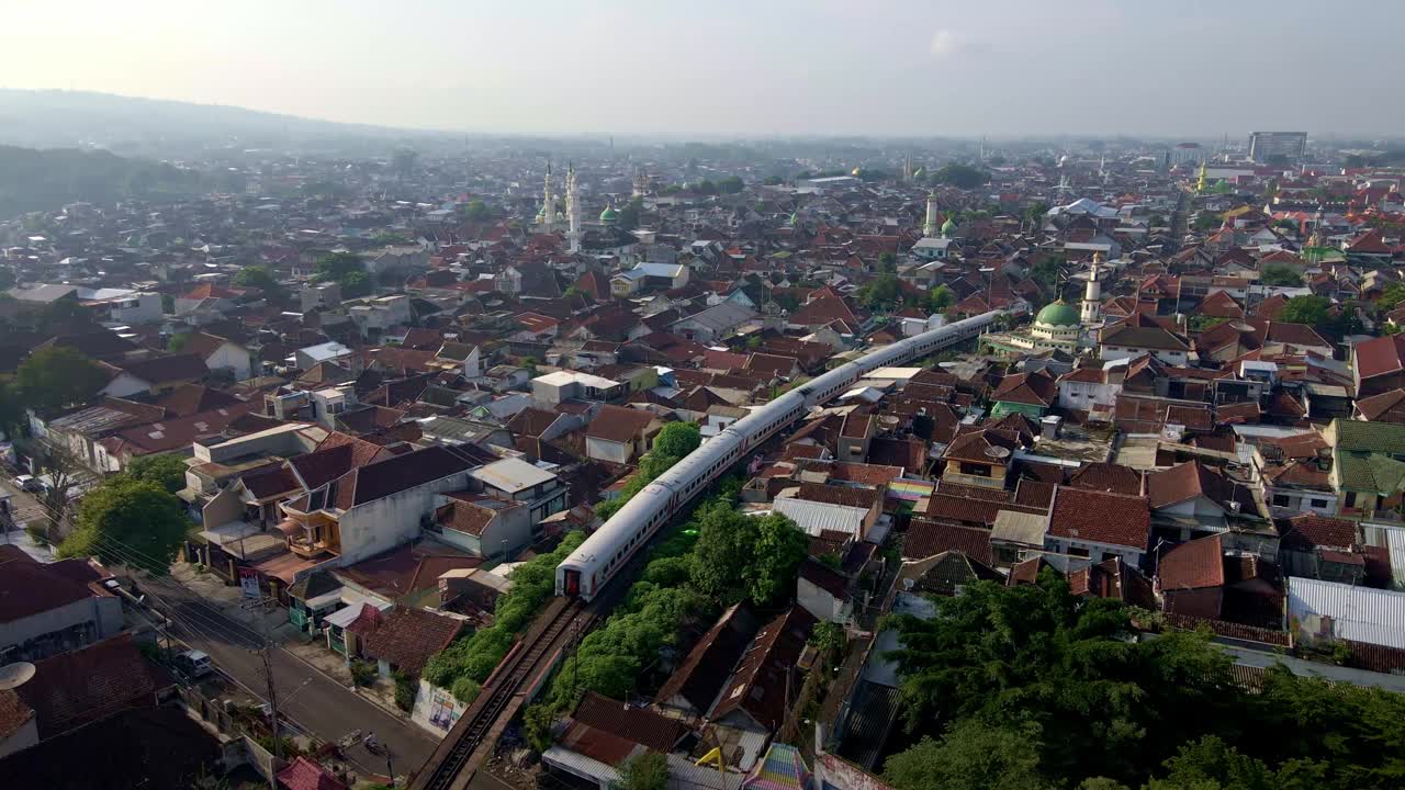 印尼人口稠密的贫民窟，铁路贯穿其中。展现了熙熙攘攘的城市景观中的城市贫困。航拍4k无人机画面视频素材
