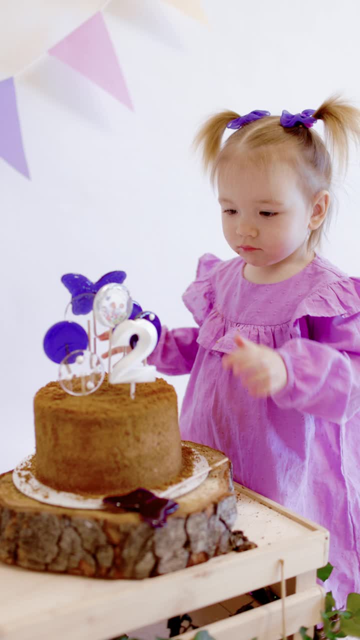 可爱的小女孩在家里用生日蛋糕上的糖果庆祝生日视频素材