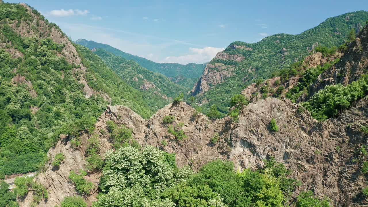 碧蓝的天空下葱郁的青山，穿过山谷的河流视频素材