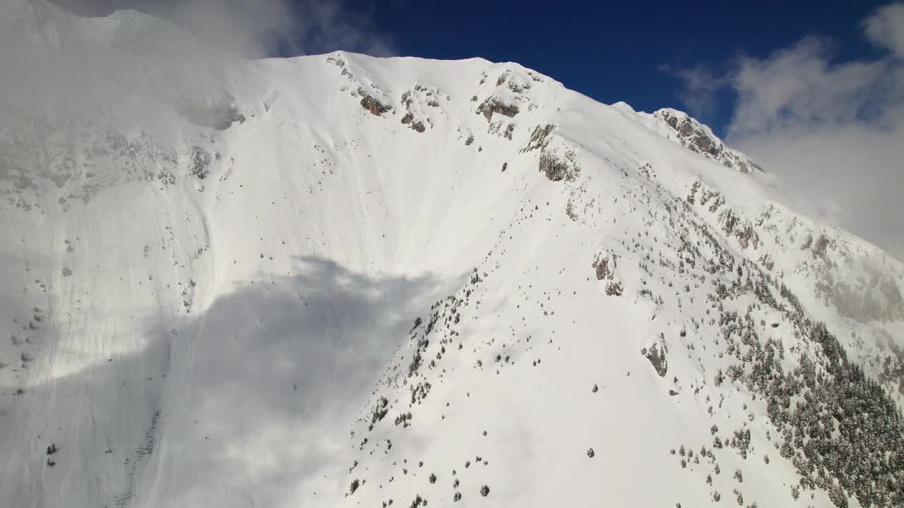 白雪覆盖的La Om峰在Piatra Craiului山脉清澈的蓝天下，鸟瞰图视频素材