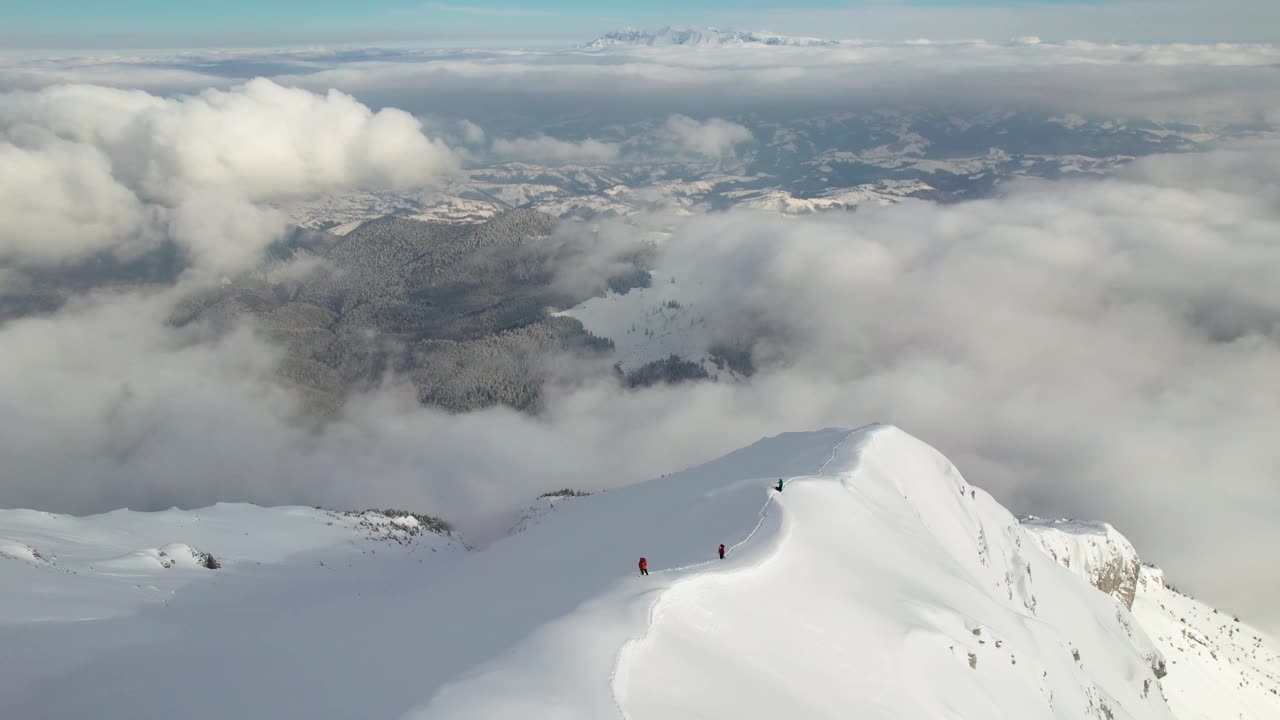 鸟瞰Piatra Craiului山脉，白雪覆盖的山峰穿透白云视频素材