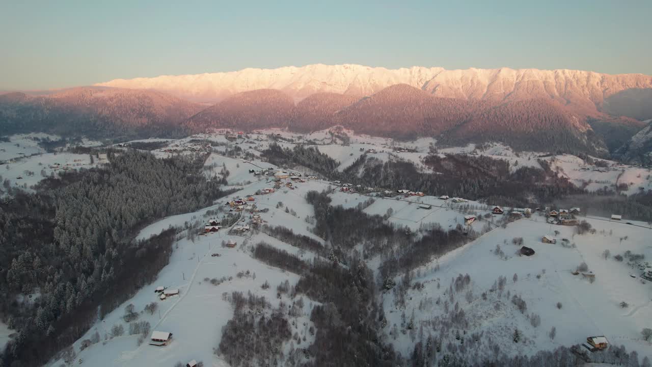 空中拍摄的日出时的皮亚特拉克雷乌鲁伊山脉和白雪覆盖的村庄视频素材