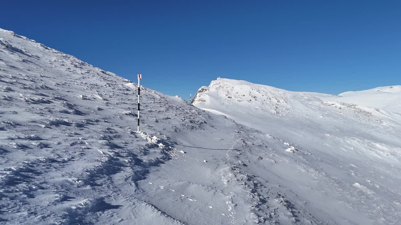 白雪皑皑的布塞吉山坡，远处是伊泽-帕普萨和皮亚特拉-克雷乌鲁伊，蓝天视频素材