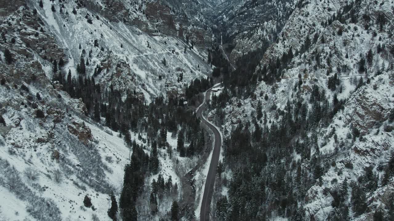 美国犹他州冬季美国福克峡谷高耸陡峭山脉上的道路。无人机航拍视频素材