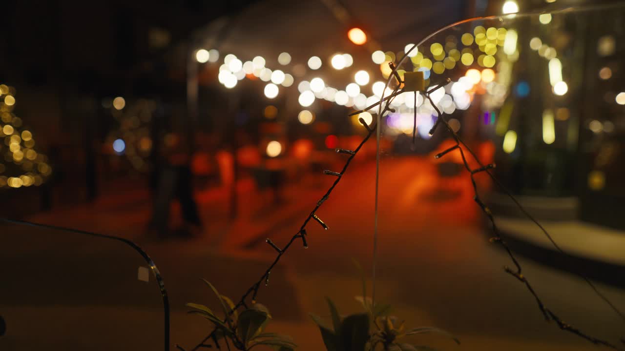 一段夜间街道的模糊视频，前景有带刺的铁丝网视频素材