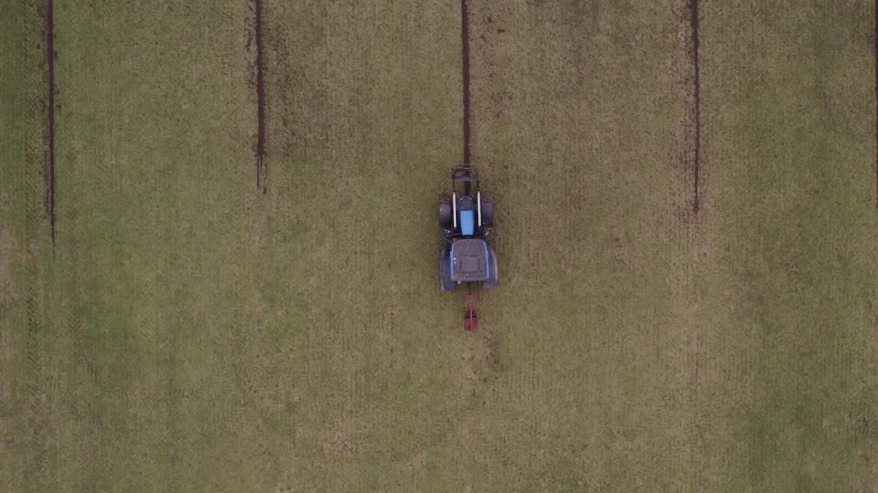 荷兰，在草地上用农具挖沟的拖拉机鸟瞰图视频素材