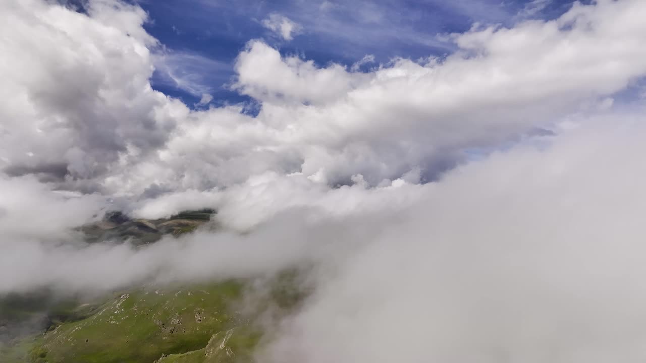 向后运动。在晴朗的日子里，云中移动的航拍延时视图。视频背景在厚厚的云层中飞行视频素材