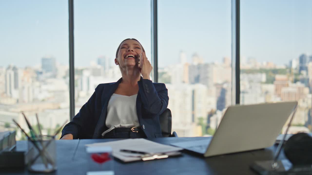 快乐的女商人在全景窗口打电话。微笑女士休息视频素材