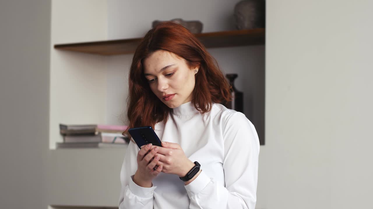 幸福的商业女性肖像享受成功的手机在家里或办公室。特写:快乐的女孩用慢动作读手机上的好消息。惊讶的女士在电话里庆祝胜利视频下载