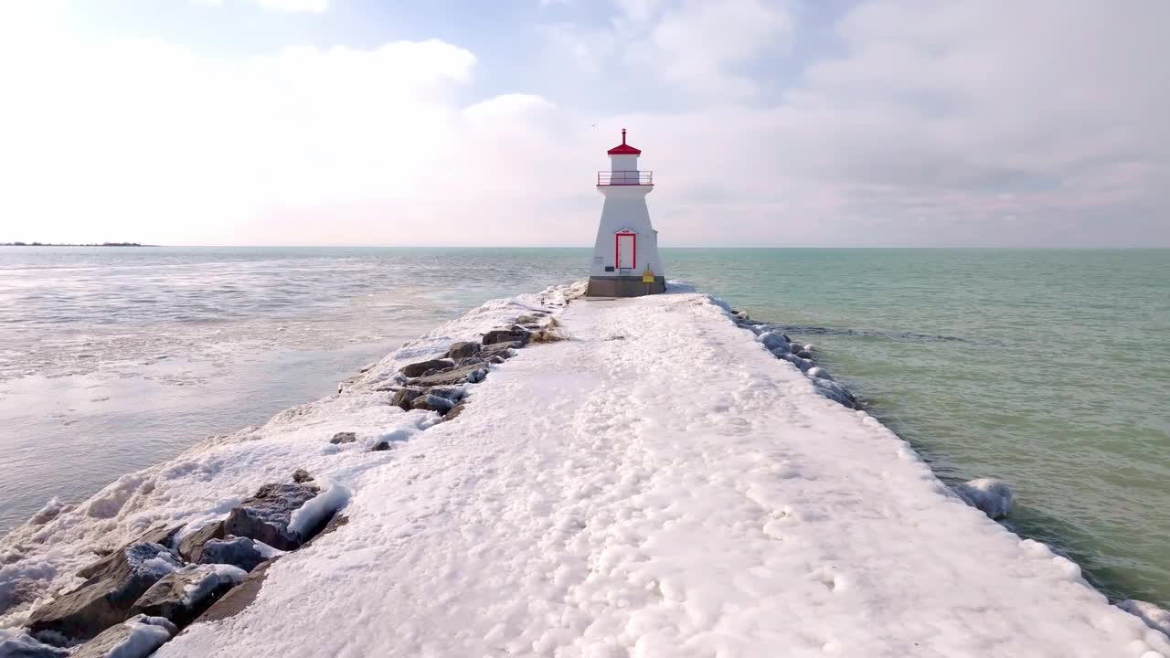 多云的天空下，通往南安普顿灯塔的积雪码头的冬日景象视频素材