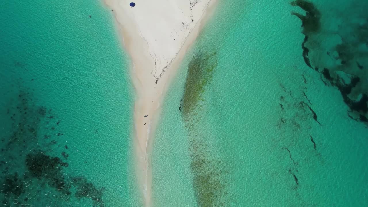 鸟瞰图，一条狭窄的沙质小路将碧绿的海水分隔开来视频素材