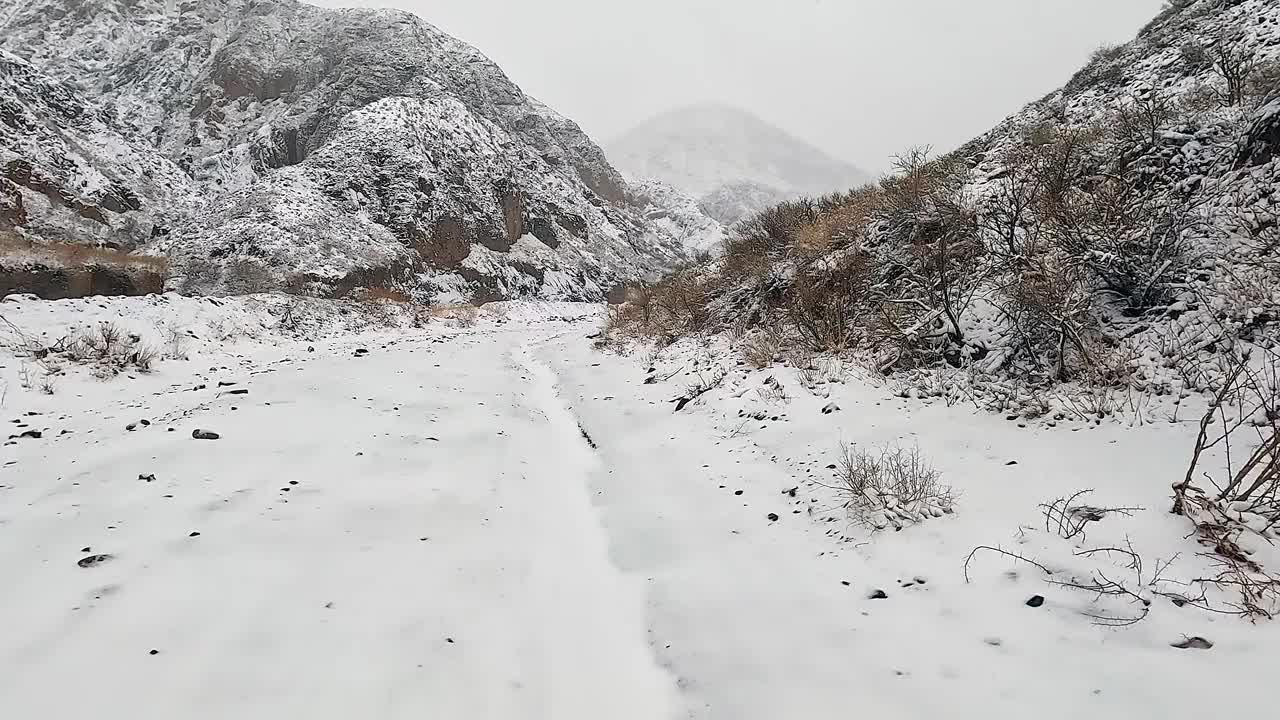 小雪中沿着雪山公路行驶的汽车。Konorchek峡谷。令人惊叹的冬季景观。视频下载