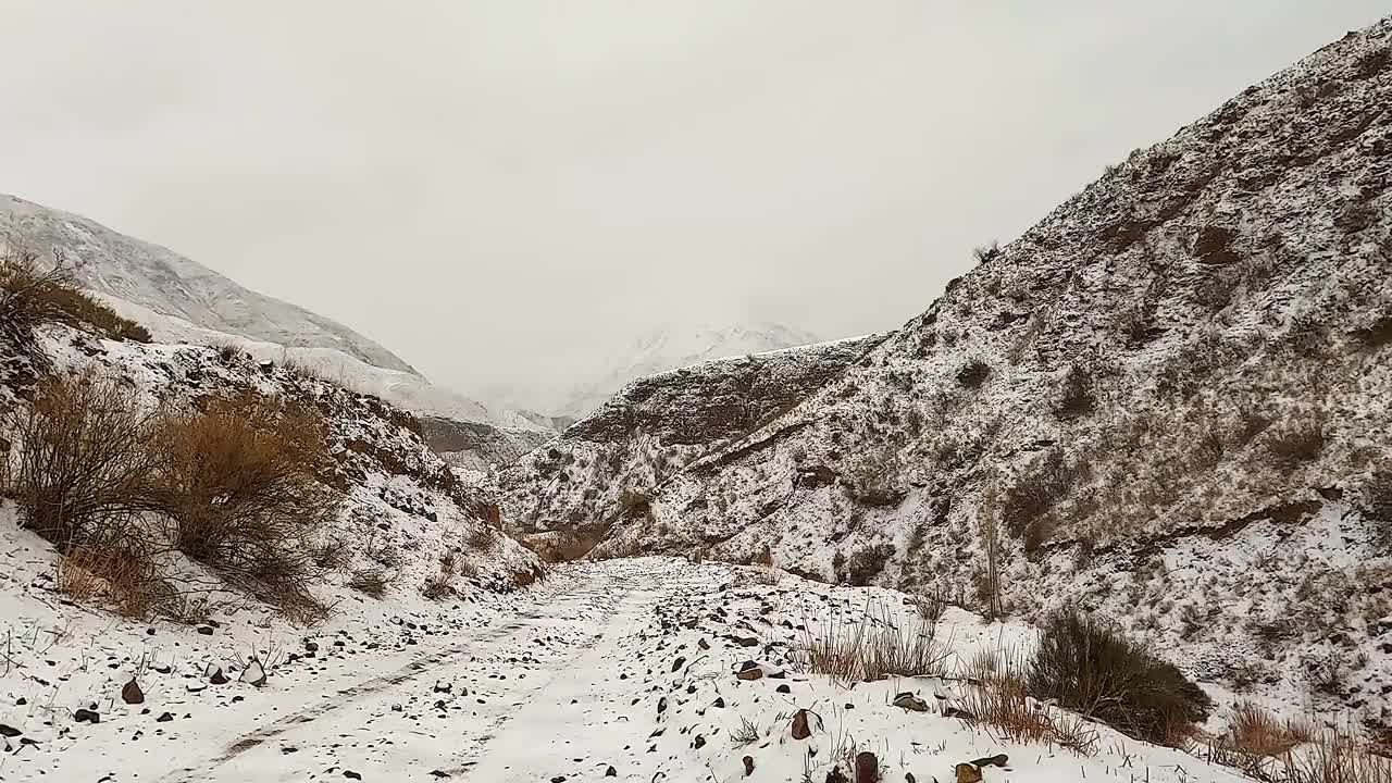 骑在冬天的山路上。康内克峡谷。美丽的冬季景观。在吉尔吉斯斯坦开车旅行视频下载