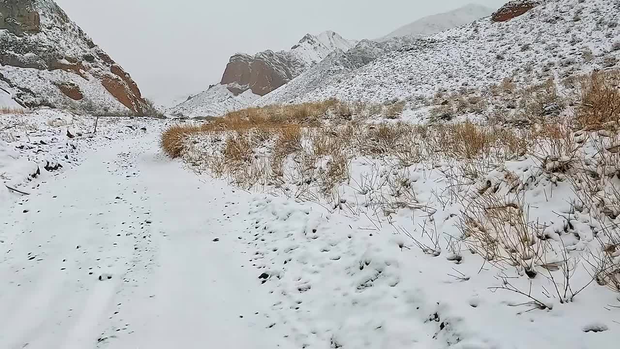 在雪山路上开车。Konorchek峡谷。冬天去吉尔吉斯斯坦旅行。视频下载