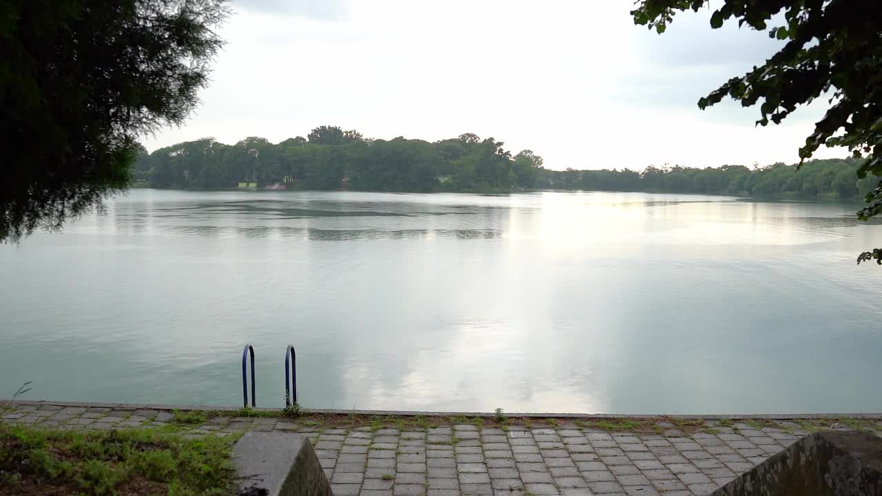 在雨天通往湖边的楼梯上的金属扶手视频素材