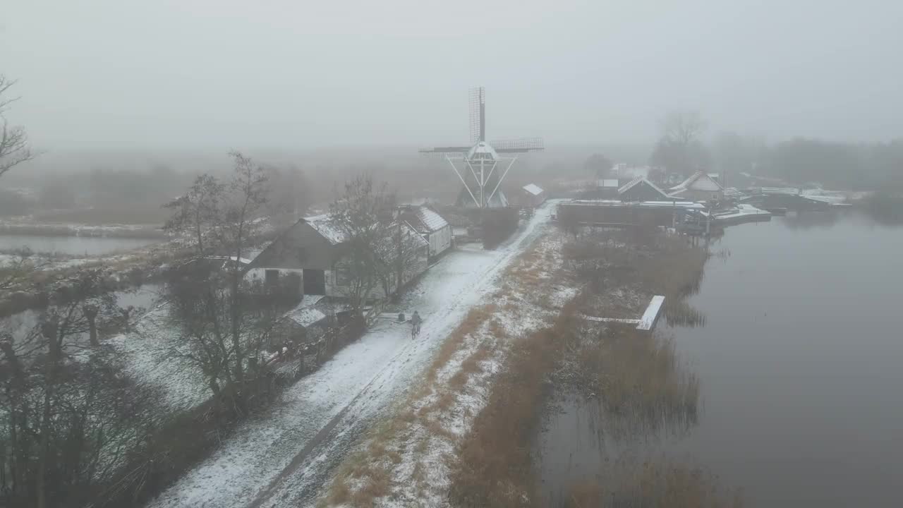 鸟瞰图的男子骑自行车在泥泞的道路上与雪在冬天视频素材