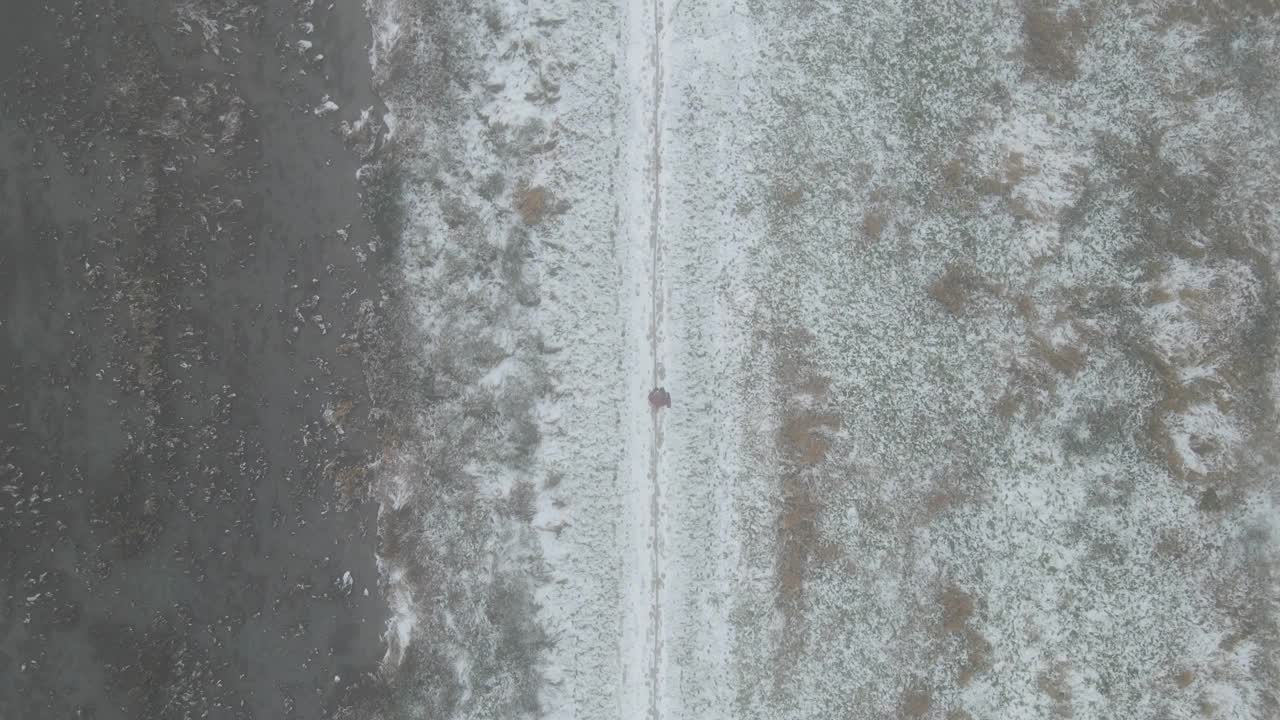 鸟瞰图的女人跑在砾石路径在冬天的雪视频素材