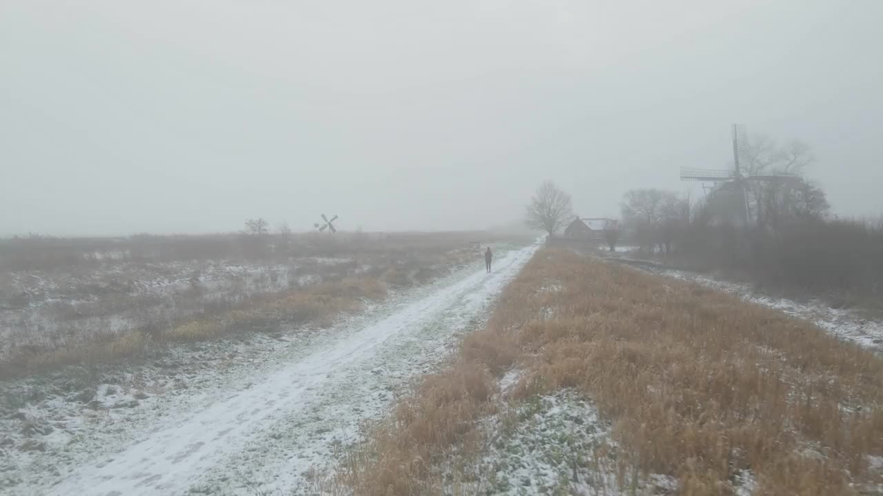 鸟瞰图的女人跑在砾石路径在冬天的雪视频素材