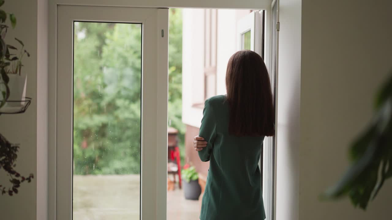 沮丧的女人凝视着窗外的雨视频素材