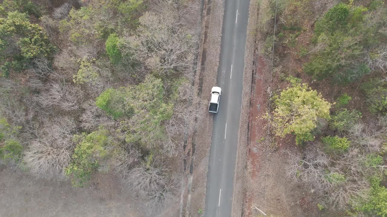 无人机拍摄鸟瞰风景，驾驶皮卡车在旱季偏僻的乡村道路上行驶视频素材