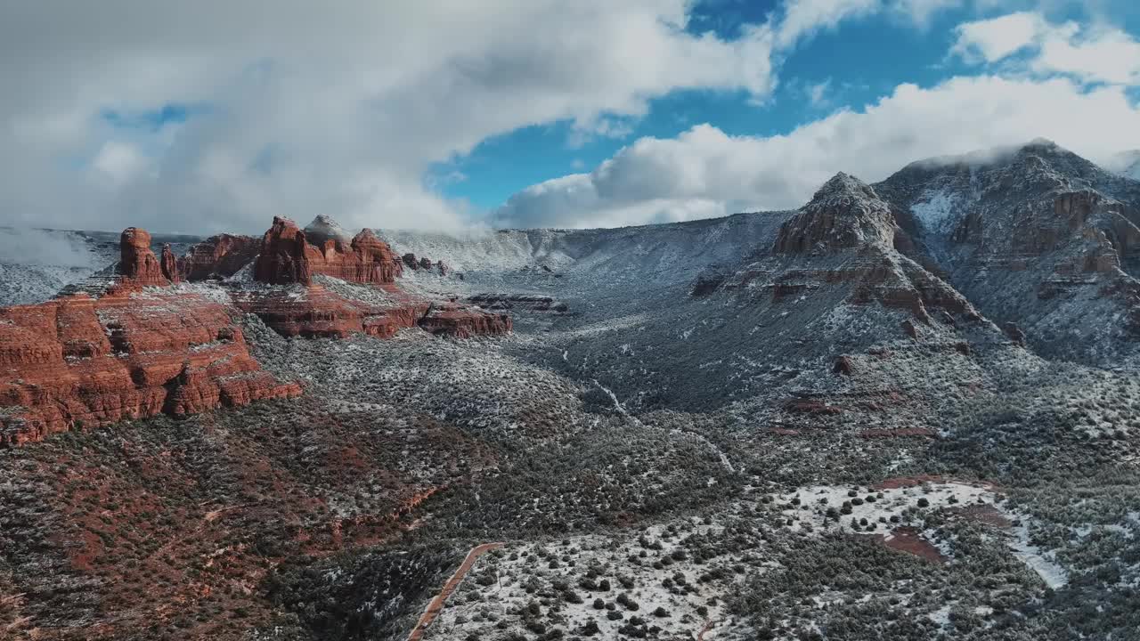 红色砂岩岩层的全景覆盖在雪在冬天。-空中下降视频素材