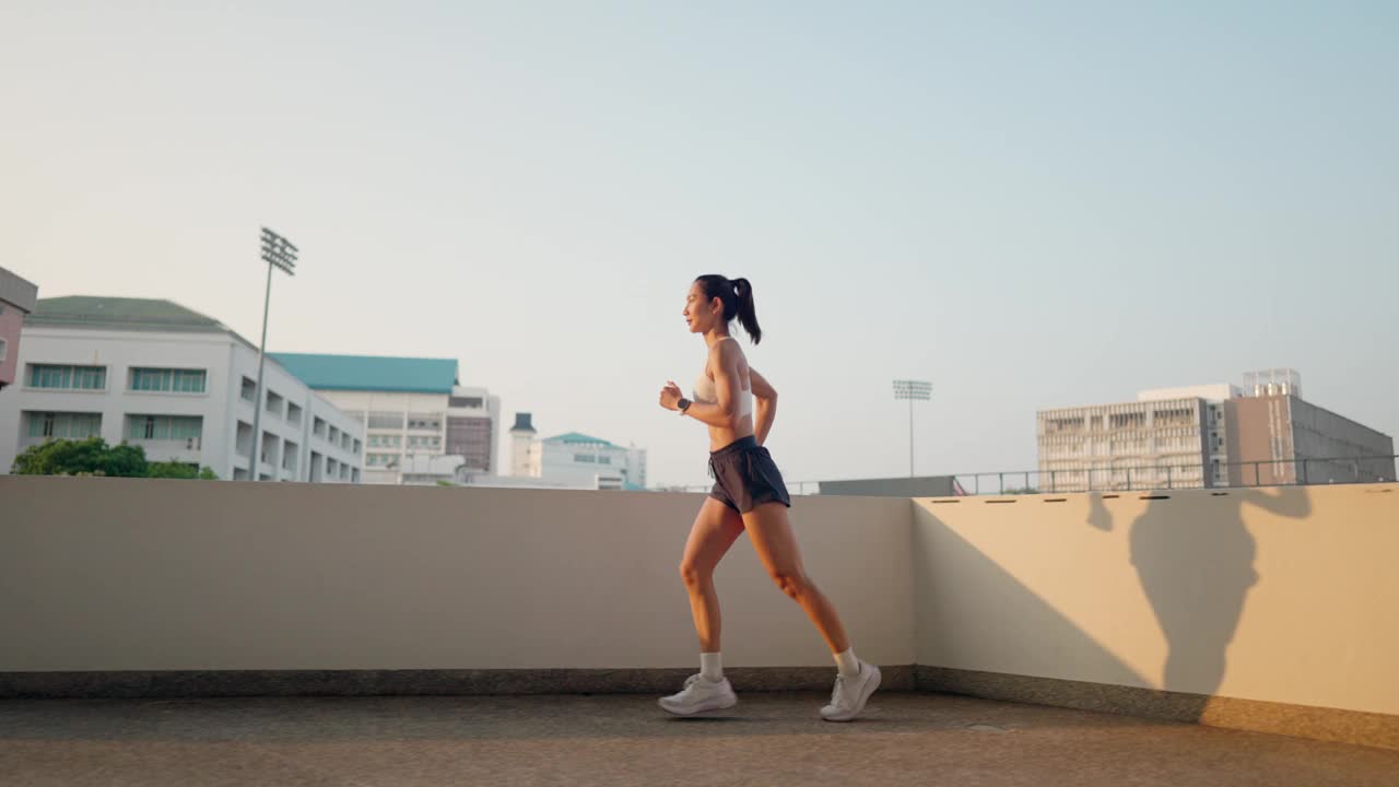 一个女人在城市的屋顶上跑步视频素材