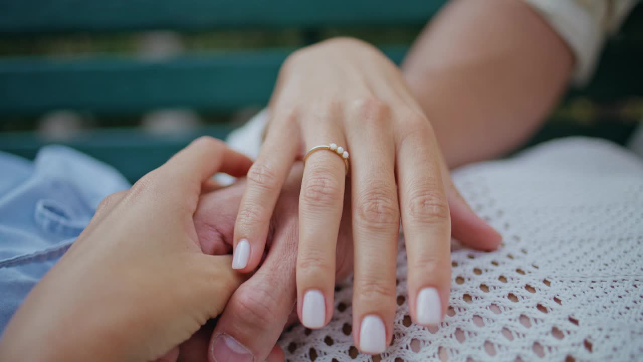 特写:年轻情侣在浪漫的约会中手牵着手。订婚的男人女人爱视频素材