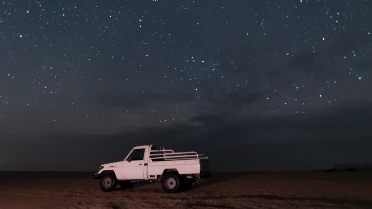 空旷的沙漠中骆驼农场营地上空夜空银河的流逝视频下载