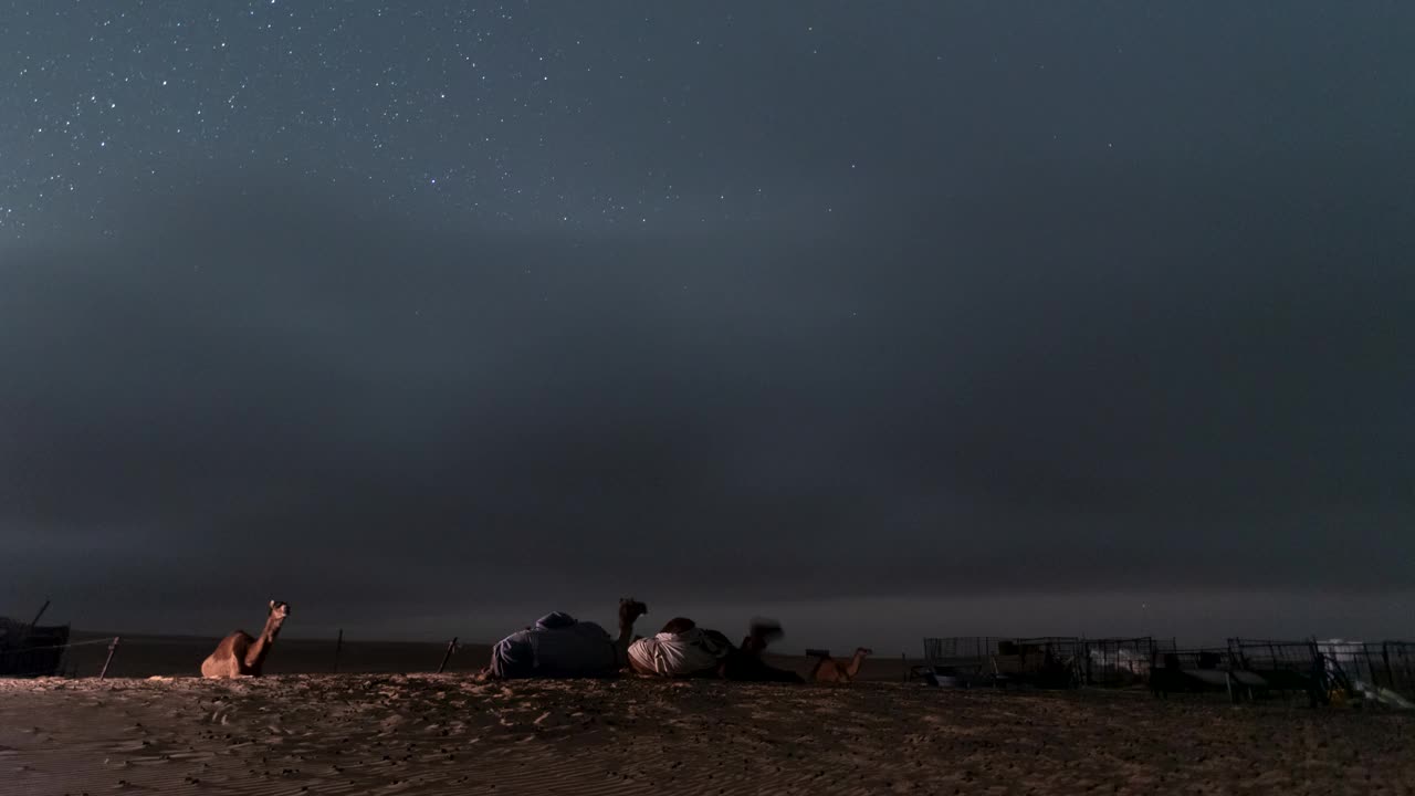 空旷的沙漠中骆驼农场营地上空夜空银河的流逝视频下载