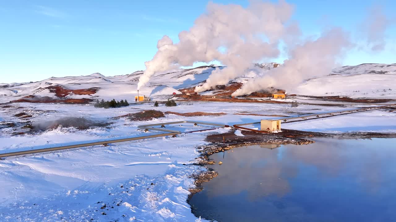 在一个晴朗的雪天，蒸汽从Myvatn地热发电厂升起，旁边是一个鲜艳的蓝色湖泊视频素材