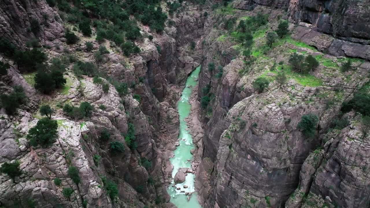 这幅航拍无人机画面捕捉到了安塔利亚塔兹尔峡谷的壮丽景色，峡谷很深，一条河流蜿蜒在高耸的悬崖之间。视频下载