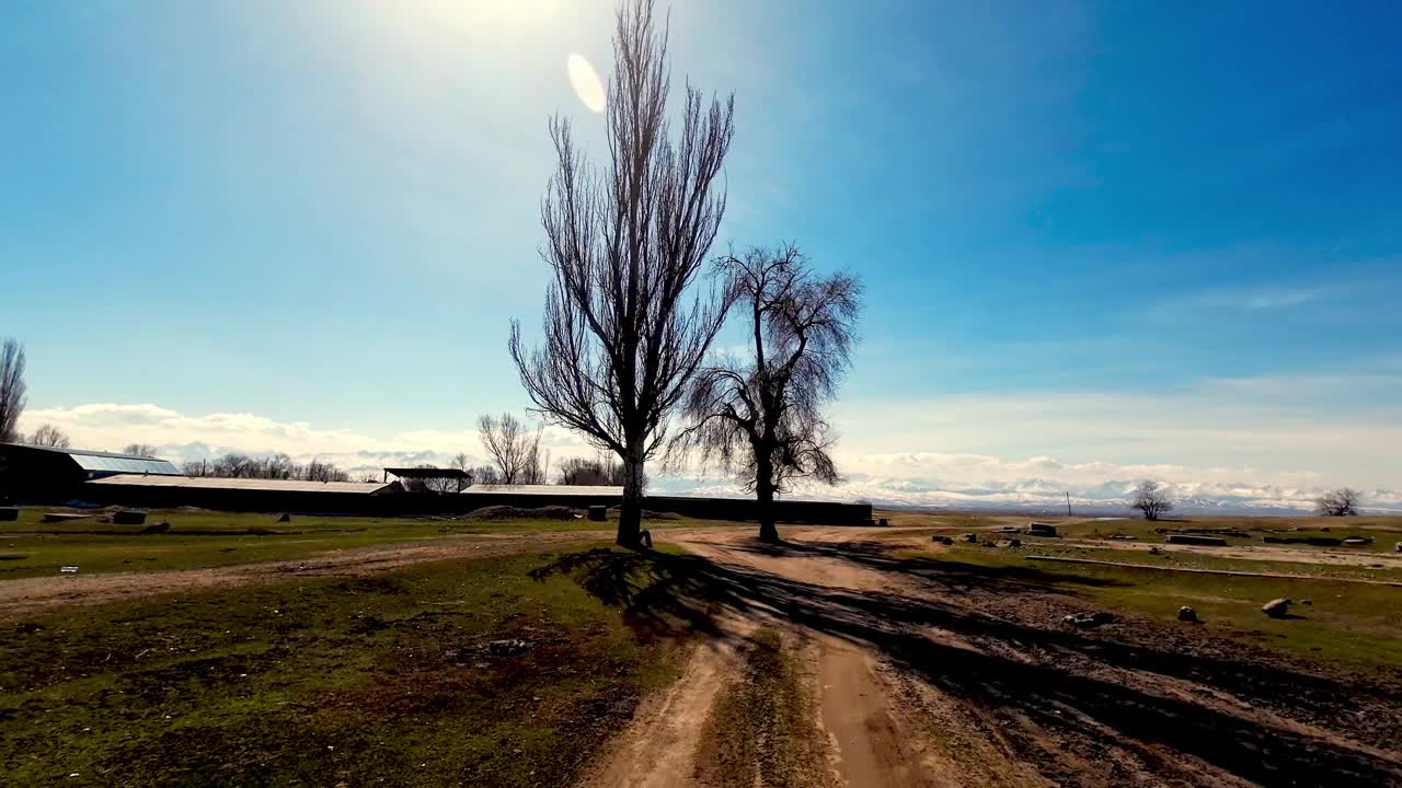 在湖岸被毁坏的农场旁的泥土上行走视频素材