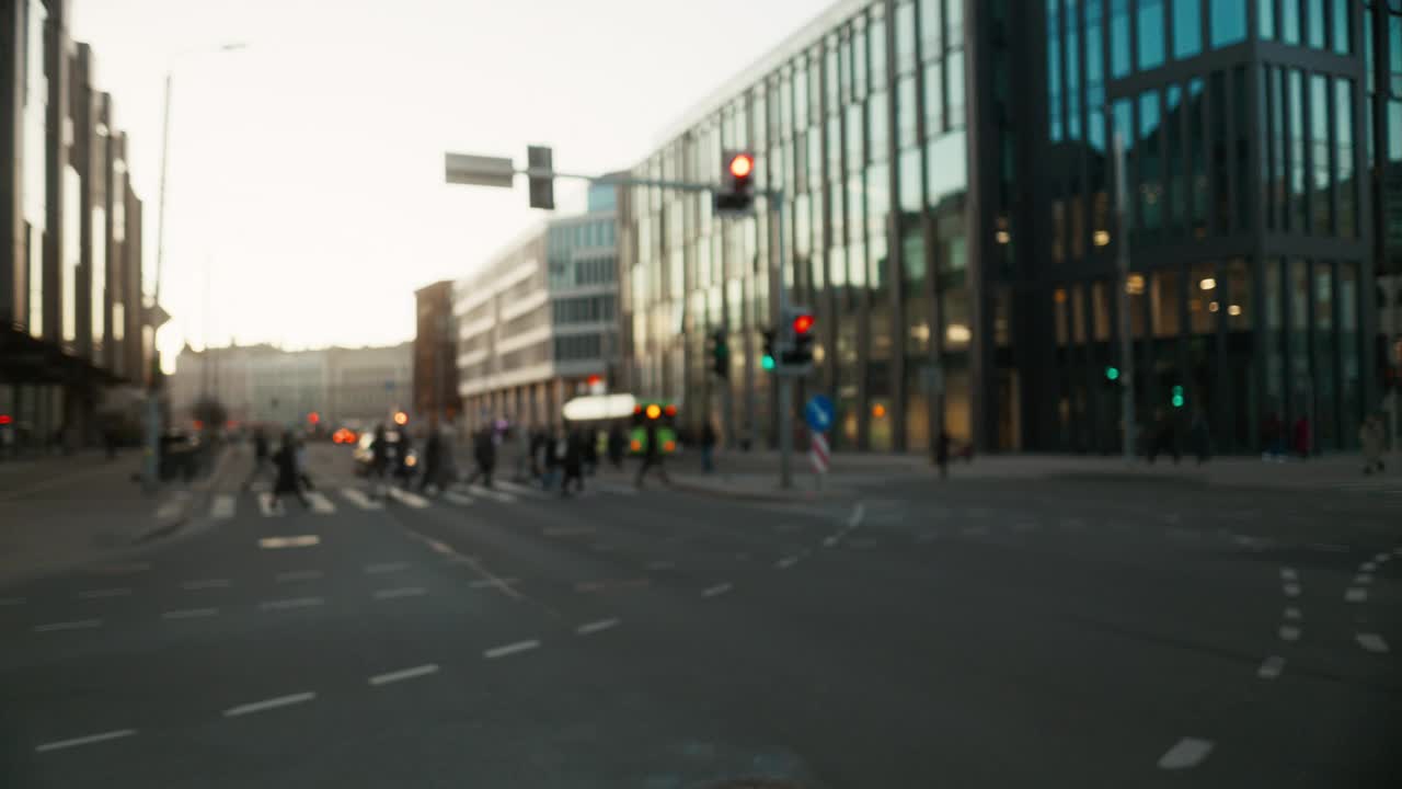 人们穿过熙熙攘攘的城市街道，街道上有高楼大厦和沥青路面视频素材