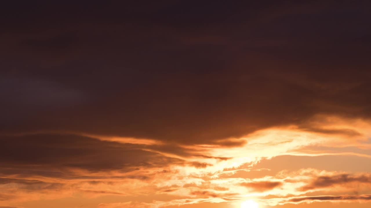 时间流逝的巨大蓬松的橙紫色云快速移动在夕阳的天空在柔和的颜色视频下载