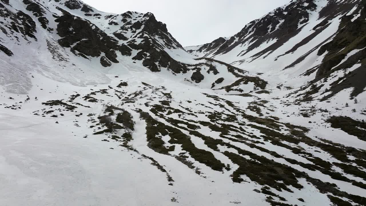 晚春自由骑行时，鸟瞰部分积雪覆盖的峡谷视频素材