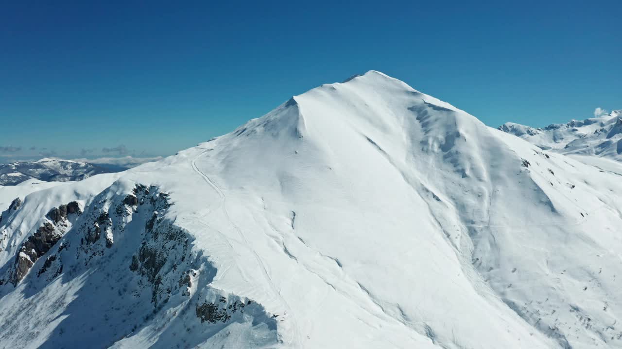 蓝天下白雪皑皑的山峰，从空中拍摄视频素材