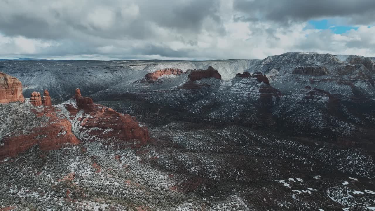 阳光明媚的冬日，美国亚利桑那州，塞多纳的雪红色岩石。空中回射视频素材