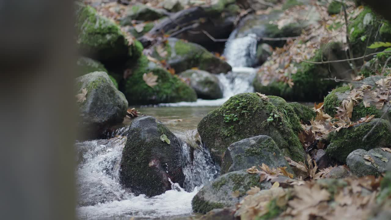 瀑布般的河水缓缓流过山间的岩石，一派宁静的景象视频素材