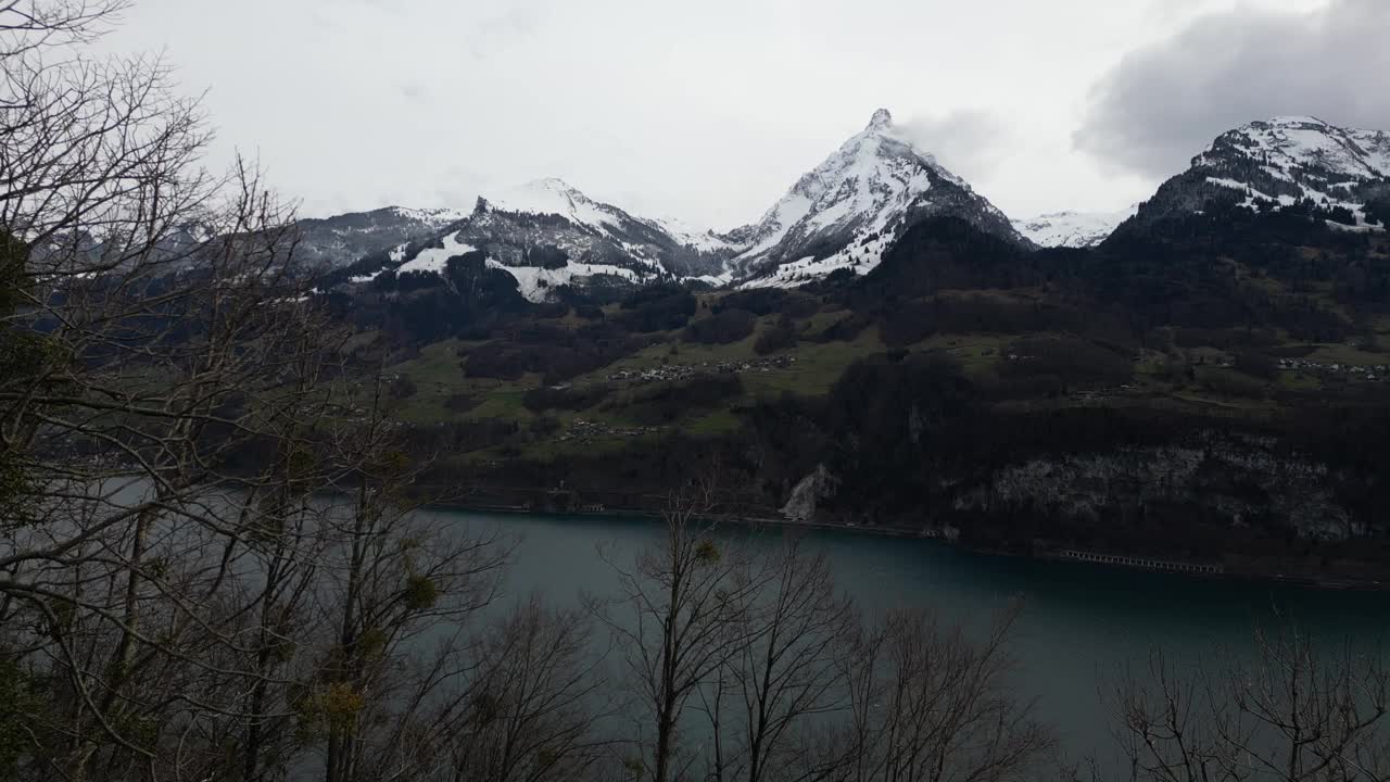 无人机在瑞士多云的天空下拍摄的白雪覆盖的山脉。视频素材