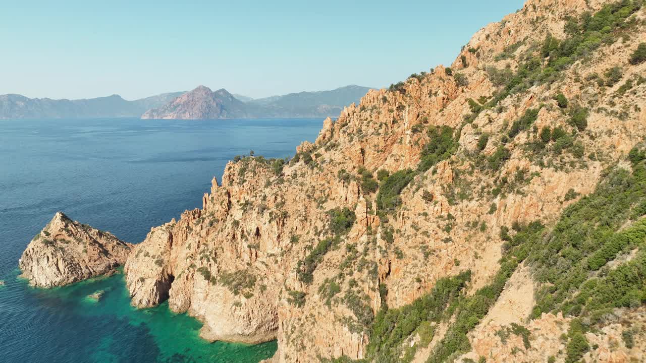 科西嘉岛崎岖的海岸线，湛蓝的大海，金色的阳光，多山的地形，航拍视频素材