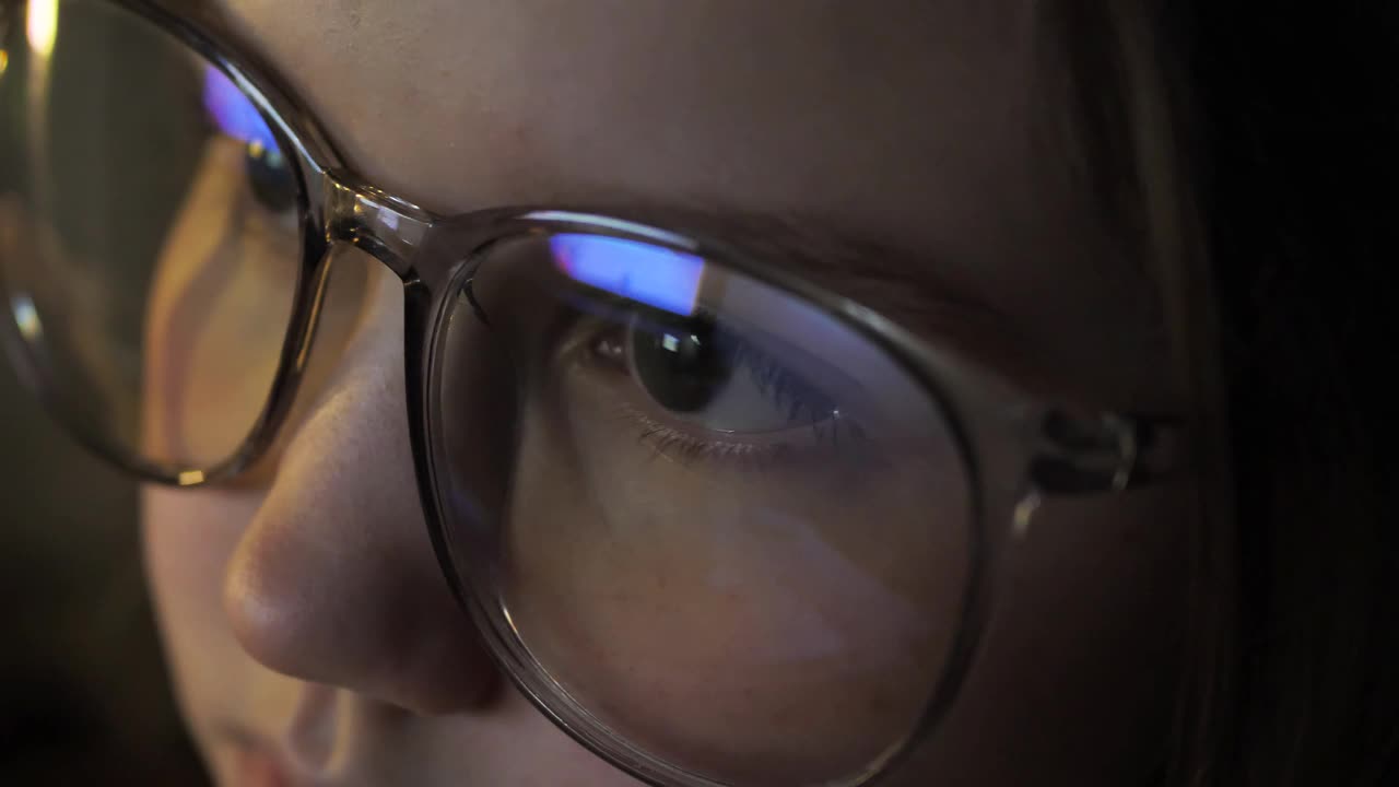 一个十几岁的女孩，戴着眼镜，晚上盯着电脑屏幕玩网络游戏。这个孩子靠近班长和朋友们聊天。儿童节目视频素材