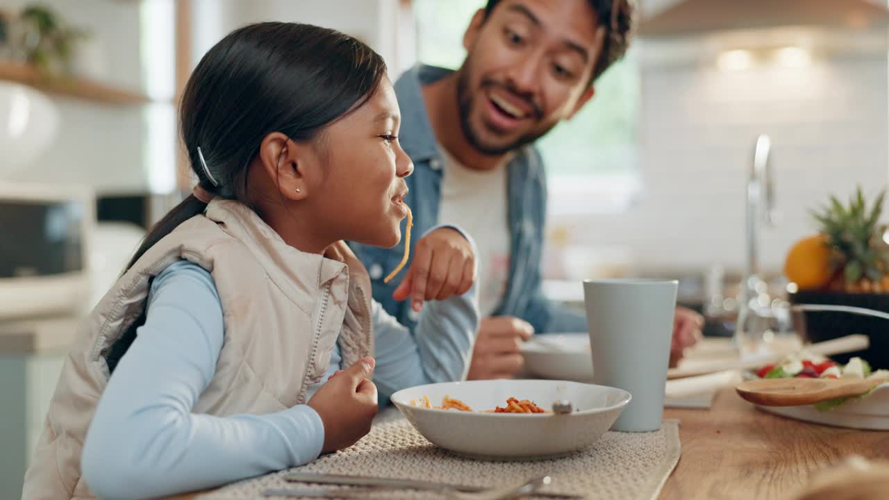 父母、孩子和一个女孩在家里的餐厅里和她的家人一起吃意大利面。食物，孩子和父亲围坐在桌子旁吃饭，在家里吃晚餐视频素材