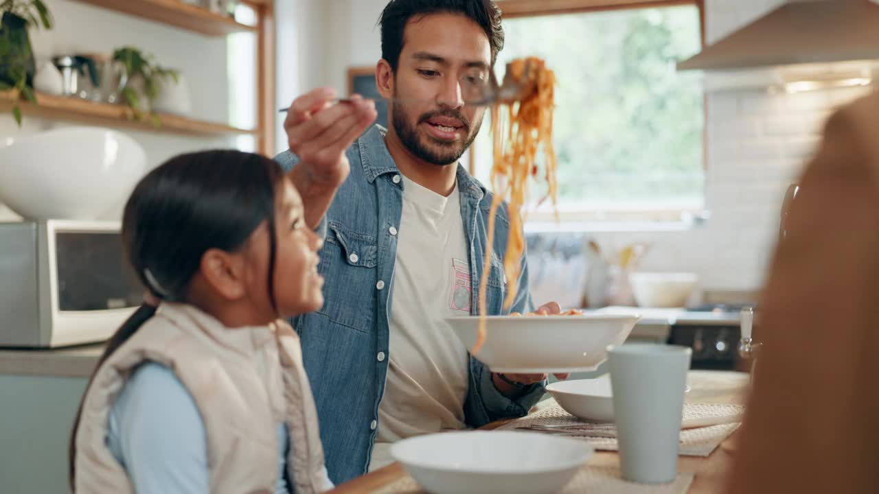 父亲、孩子们和一个女孩在家里的餐厅里和她的家人一起吃意大利面。食物，孩子和父母围坐在桌子旁吃饭，在家里吃晚餐视频素材