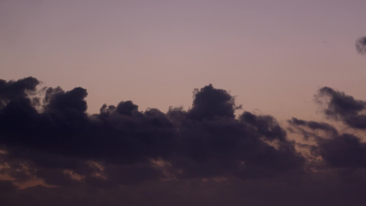 天空是一种独特的薰衣草色调，充满了快速飞行的云，在这个浪漫的延时视频中创造了令人惊叹的视觉效果。视频素材