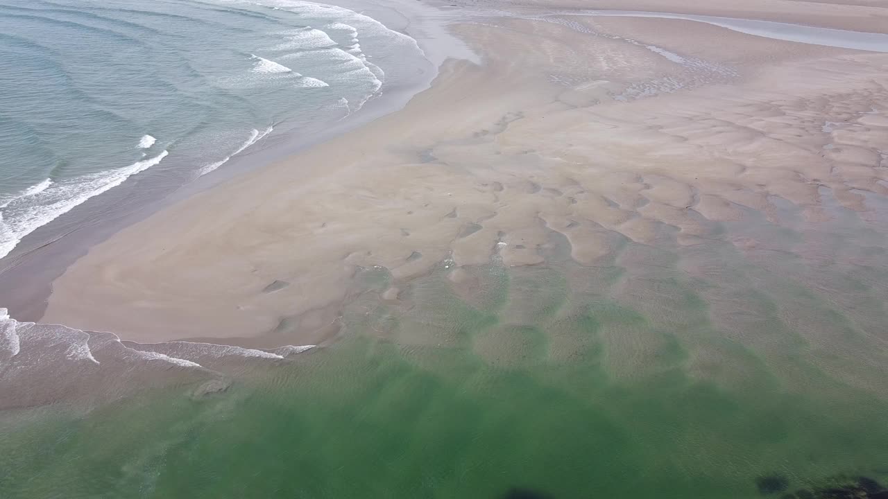 有沙滩和美丽的海浪的海滩。浪花上泛起白色的泡沫。海景俯视图，无人机视频。大西洋表面波涛汹涌，涨潮。视频素材