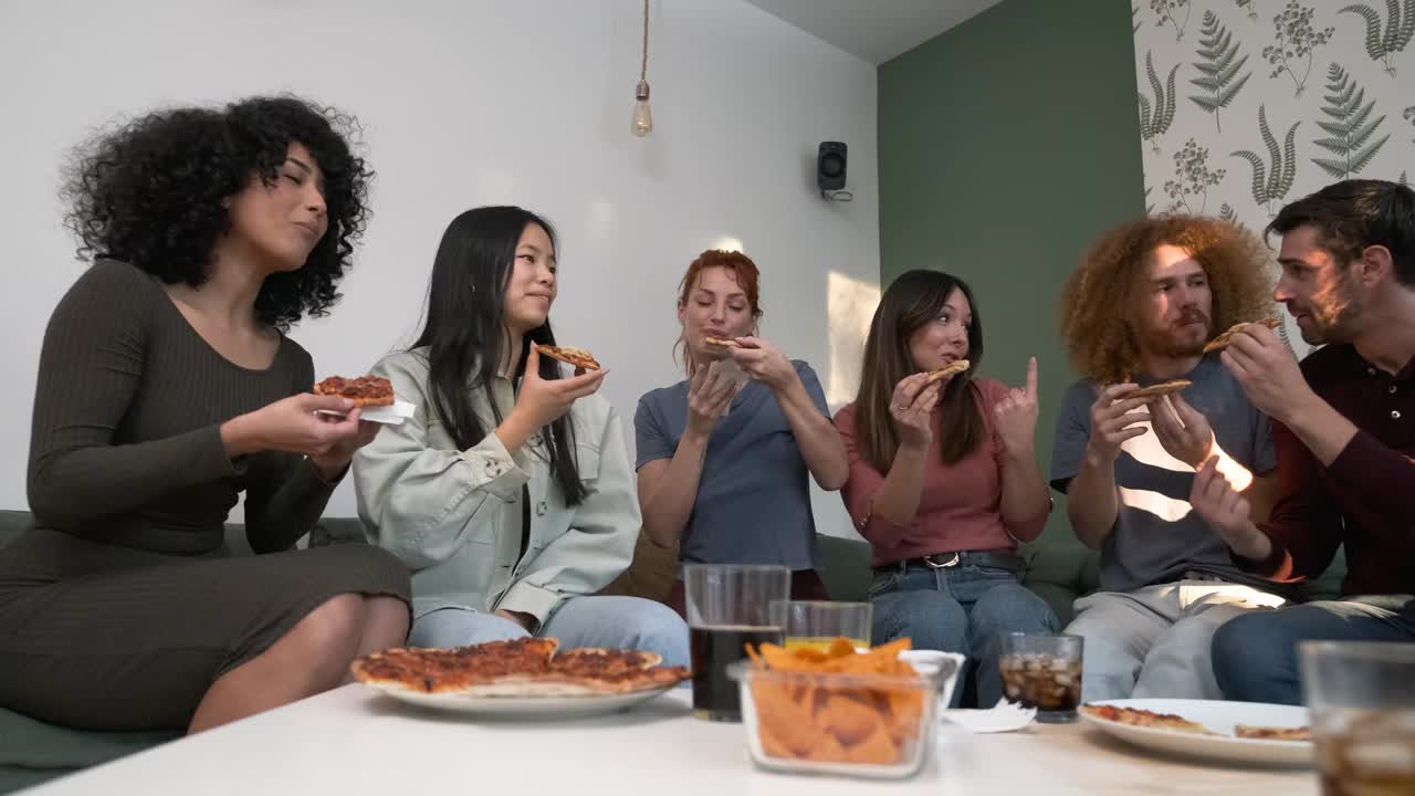 在周末的家庭聚会上，不同的朋友为带来披萨的女人欢呼视频素材