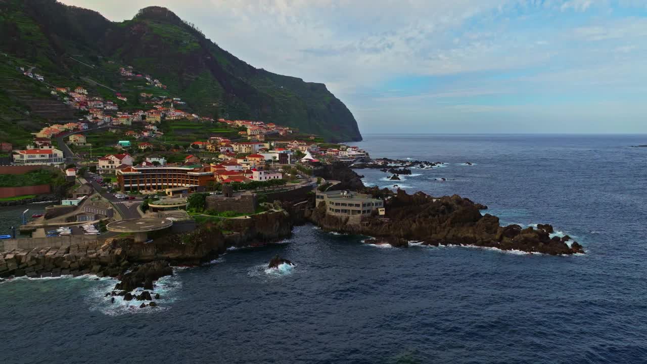 葡萄牙马德拉群岛塞萨尔鸟瞰图。坐落在陡峭海岸上的度假村庄。这个村庄坐落在一个进入海洋的火山上，被海浪冲刷视频素材