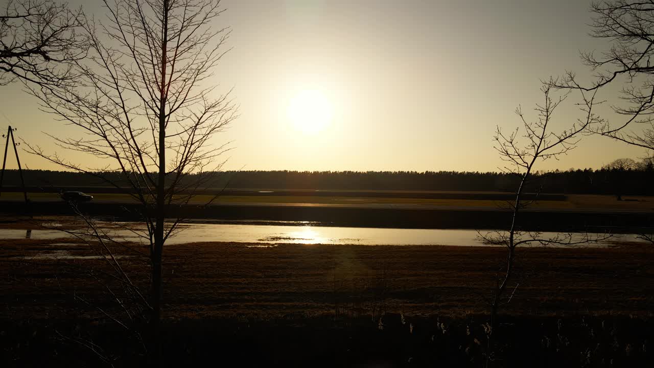 夕阳照亮水面，树木在前景，天空与云视频素材