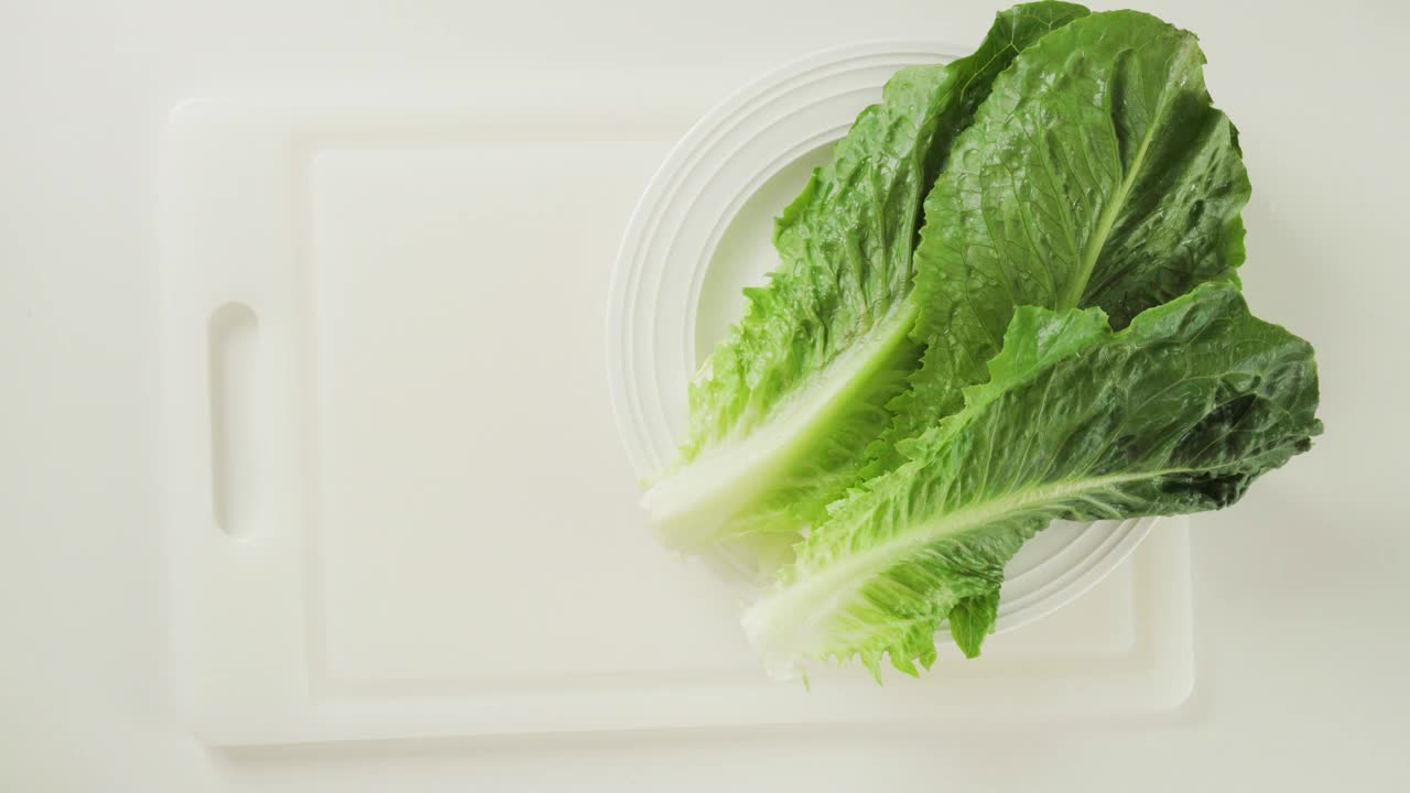 生菜，新鲜牛油果，芹菜和柠檬橄榄油调味沙拉食谱。厨房桌子上的食材特写，平放视频素材